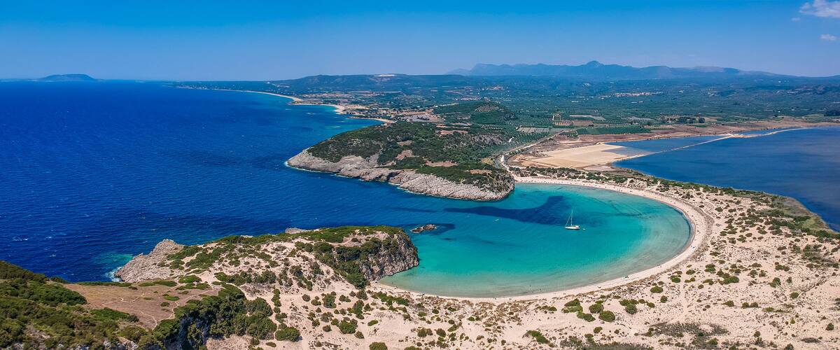 Aerial panorama view of the famous semicircular sandy beach and lagoon of Voidokilia in Messenia, Greece