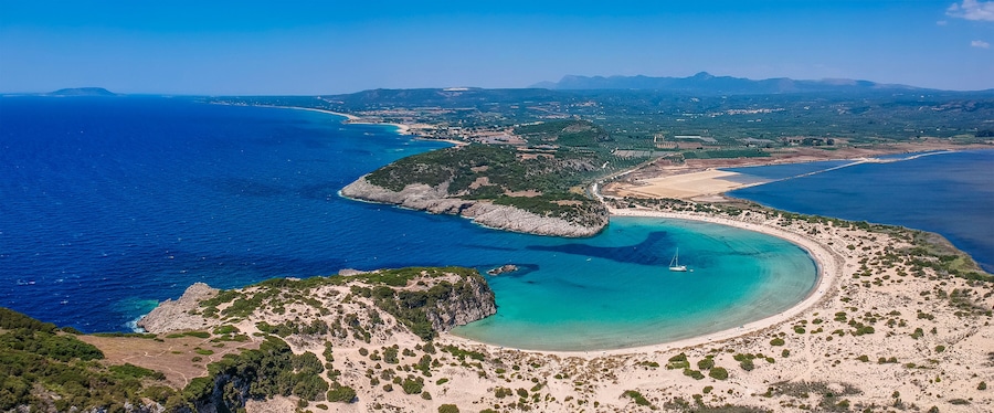 Aerial panorama view of the famous semicircular sandy beach and lagoon of Voidokilia in Messenia, Greece