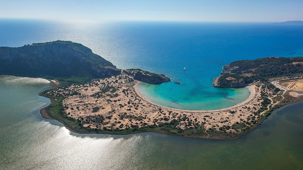 Aerial panorama view of the famous semicircular sandy beach and lagoon of Voidokilia in Messenia, Greece