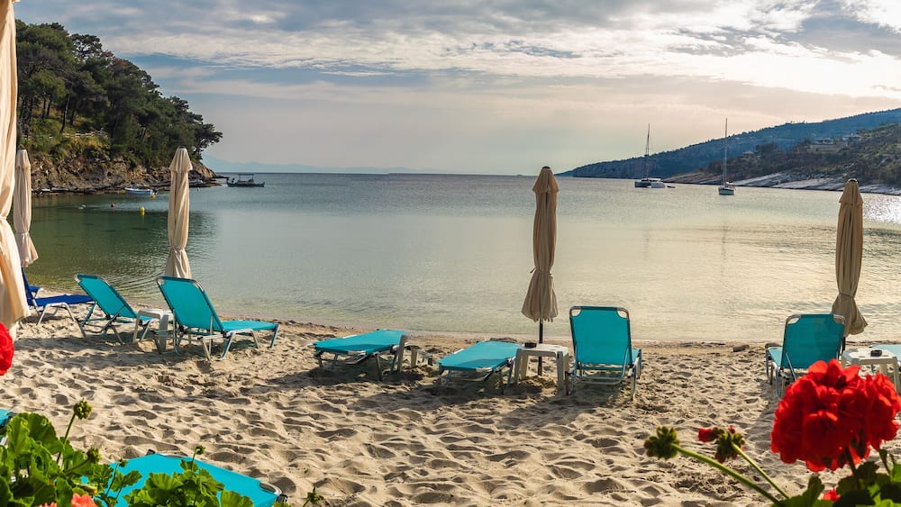 Landscape with sun umbrella and lounge chair on Aliki beach at Thassos islands, Greece