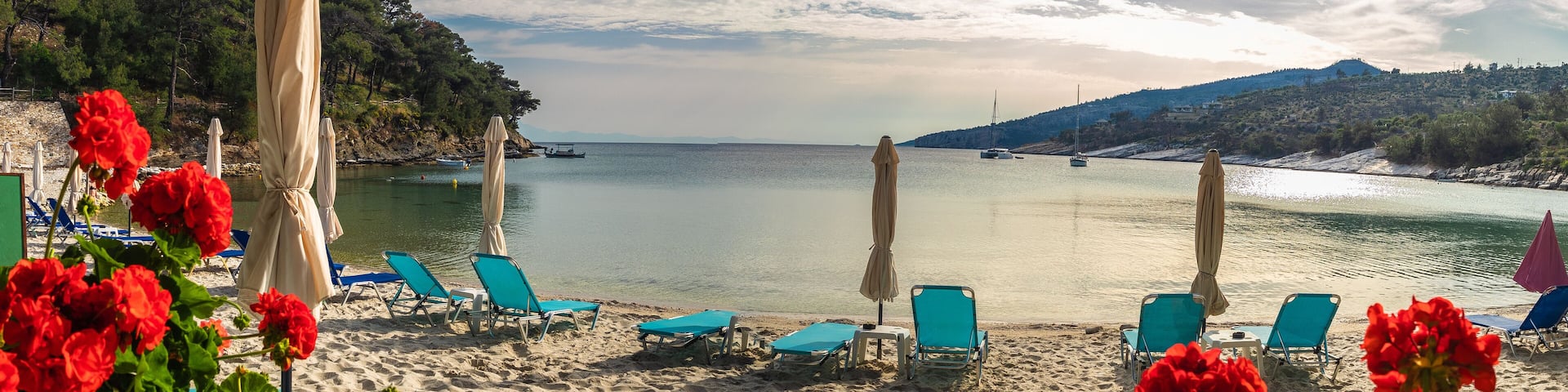 Landscape with sun umbrella and lounge chair on Aliki beach at Thassos islands, Greece