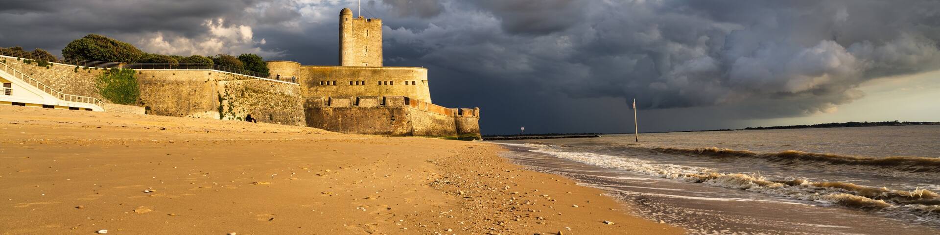 Fort Vauban de Fouras as seen from the Grande Plage beach during sunset with a storm coming in, Fouras, France