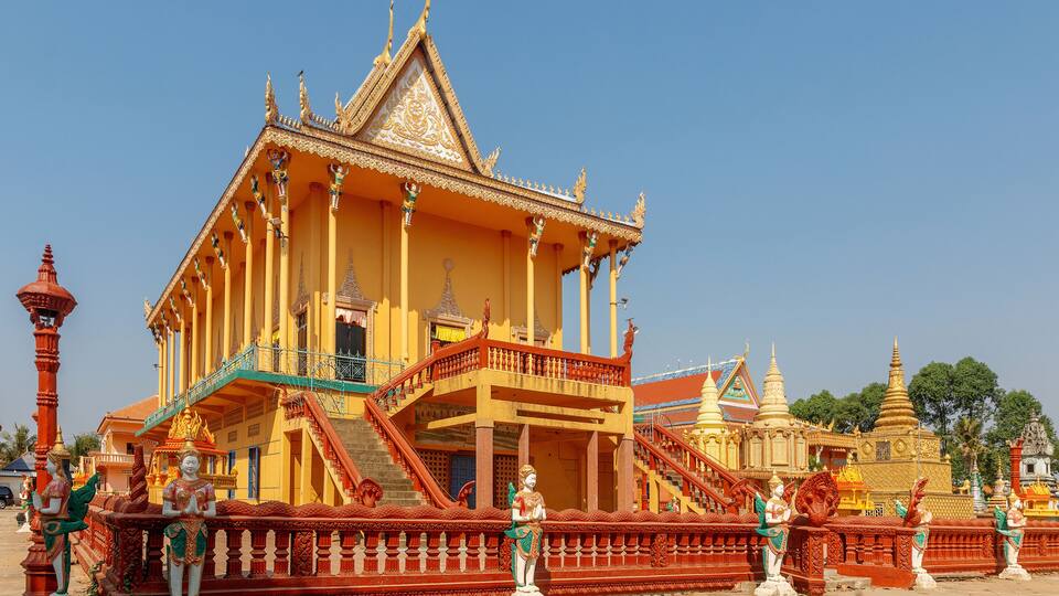 A temple with a golden roof and red railing.