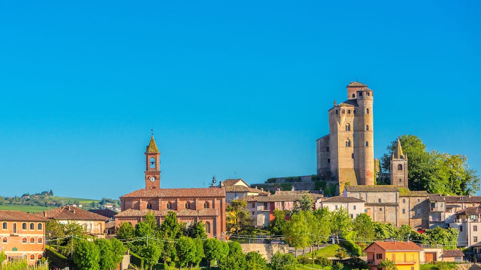 A historic town with a prominent tower and a church with a bell tower.