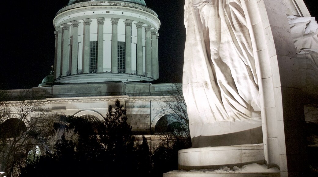 Szent István coronation statue with the dome of the Esztergom Basilica in the background. Photo taken at night in Esztergom, Hungary.