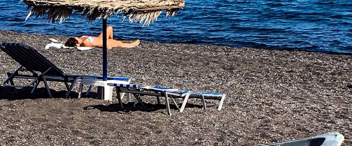 #BVSBlue
Santorini's volcanic history has led to the formation of some of the more unique beaches in the Greek Isles, and Kamari is no exception. Sitting about 4 miles southeast of Fira on the island's east coast, this stretch of black sand is one of the largest in Santorini. The beach is backed by the town of its namesake, a popular resort area where you'll find numerous hotels, restaurants, beachside bars and shops. On the beach, visitors can take advantage of the available lounge chairs and umbrellas.
Travelers enjoyed the clear blue waters of Kamari and suggested planting your feet towards the southern portion of the shore. That's because the views of the imposing Mesa Vouno hill, where you can find Ancient Thira, makes for a picture-perfect Greek beach setting. No matter where you decide to kick back on Kamari Beach, travelers strongly suggest bringing protective footwear. The sand and pebbly terrain can get quite hot with the sun beating down on it, especially after a couple hours, so bring sandals if you're hoping to spend the day on the beach. Some visitors even suggested bringing water shoes, commenting that the underwater terrain at the shore quickly goes from sand to slippery solid rock.