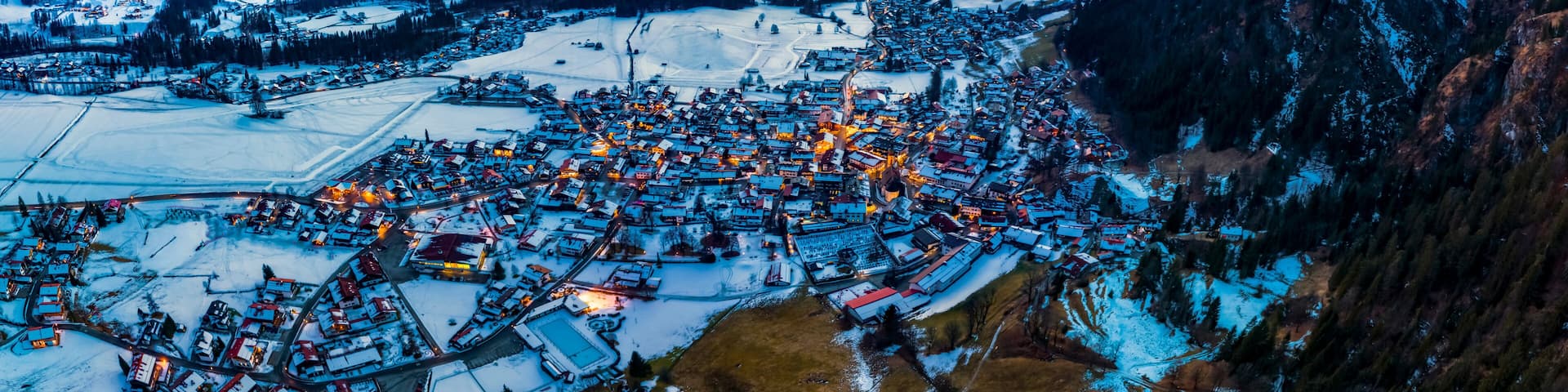 Germany, Bavaria,ÔøΩReitÔøΩimÔøΩWinkl, Helicopter view ofÔøΩsnow-coveredÔøΩmountain village at dawn
