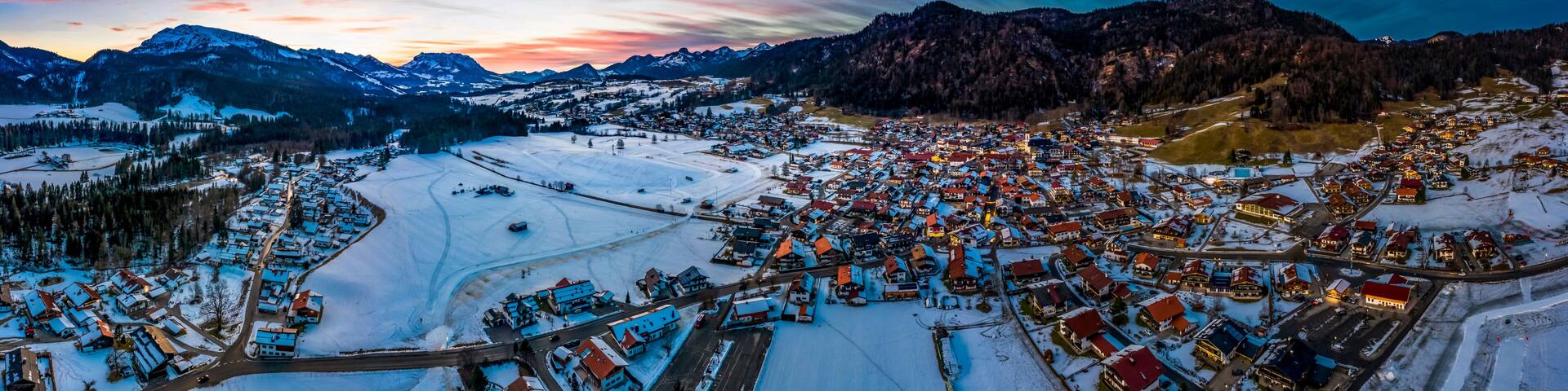 Germany, Bavaria, Reit im Winkl, Helicopter view of snow-covered mountain village at dawn