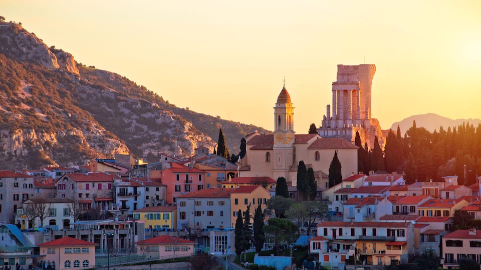 A coastal town with a prominent church, a bell tower, and a historic building with a dome.