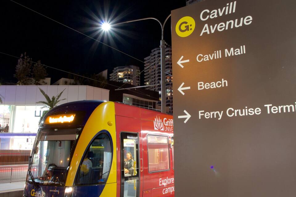 En spårvagn med en skylt som visar vägen till Cavill Avenue, Cavill Mall, stranden och färjeterminalen.