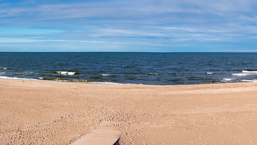 A sandy beach with gentle waves and a clear sky.