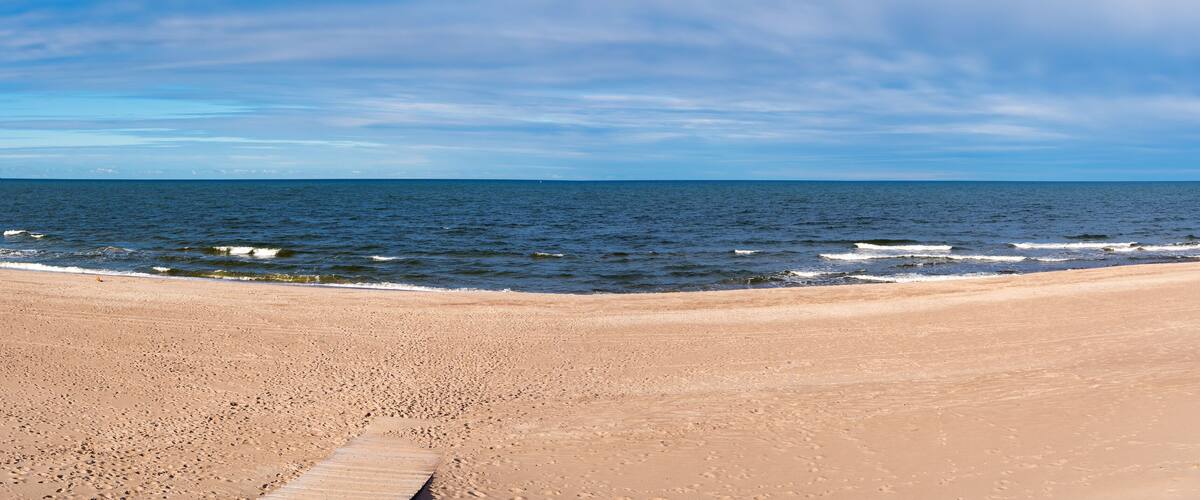 A sandy beach with gentle waves and a clear sky.