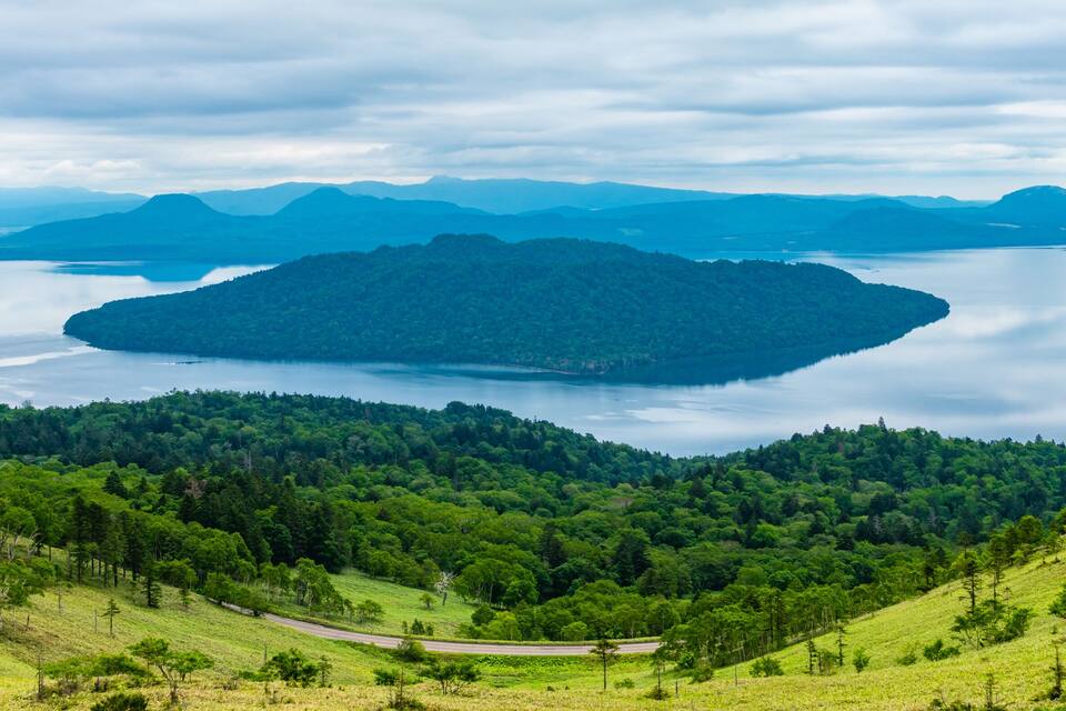 Paisatge de muntanya amb un llac envoltat de boscos densos.