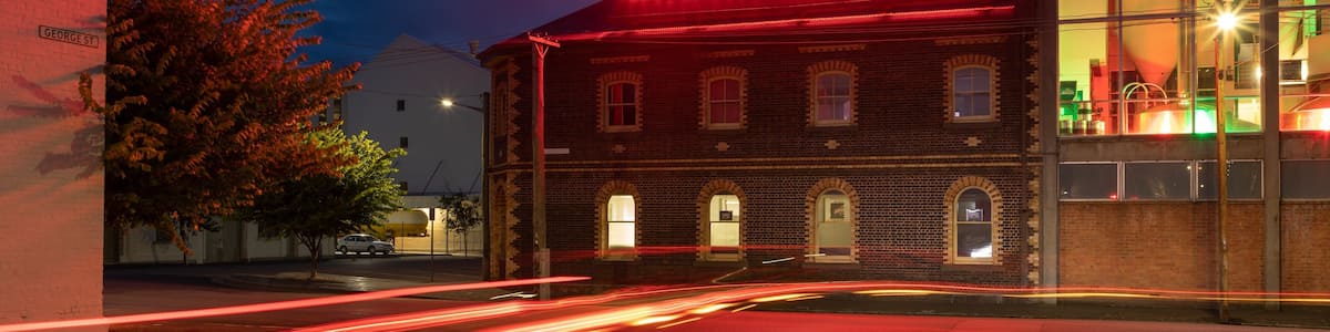Un bâtiment sur lequel est apposée une enseigne au néon indiquant « BOAGS BREWERY » la nuit.