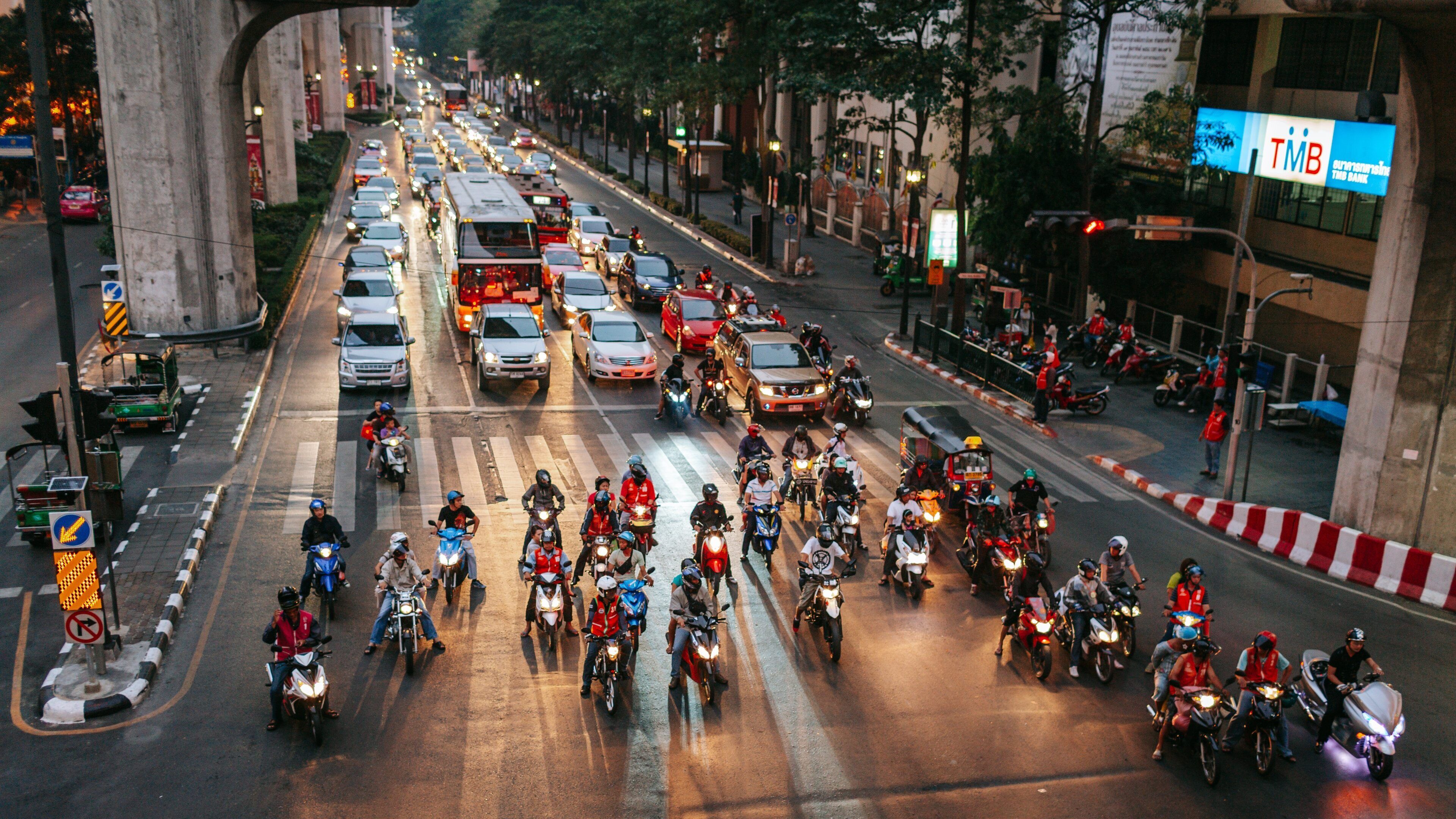 Erawan Shrine featuring landscape views and motorcycle riding as well as a small group of people