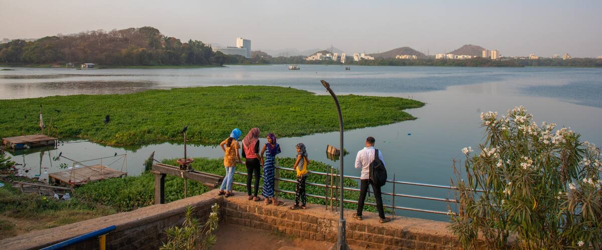 Powai Lake showing a river or creek and views as well as a small group of people