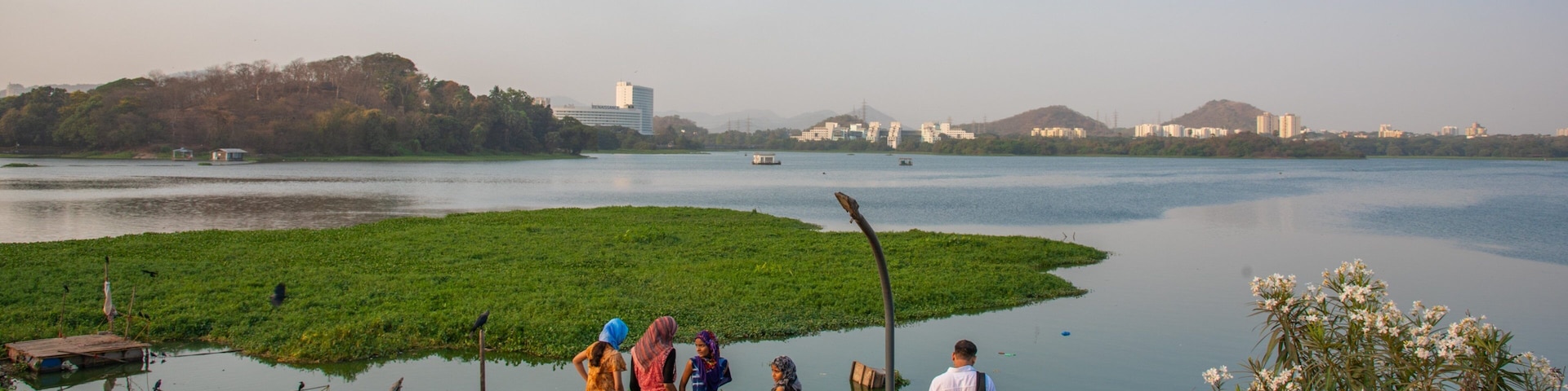 Powai Lake showing a river or creek and views as well as a small group of people