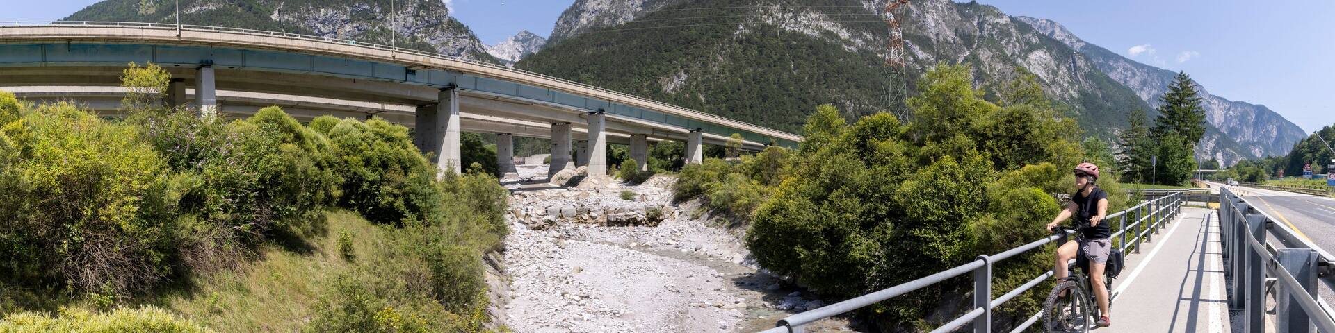 woman with e-bike on the alpe adria cycle route ( Pontebanna ) through the Val Canale in Italy