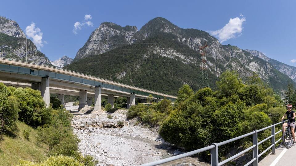 woman with e-bike on the alpe adria cycle route ( Pontebanna ) through the Val Canale in Italy