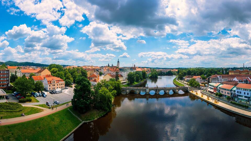 A river with a bridge, buildings, and greenery.