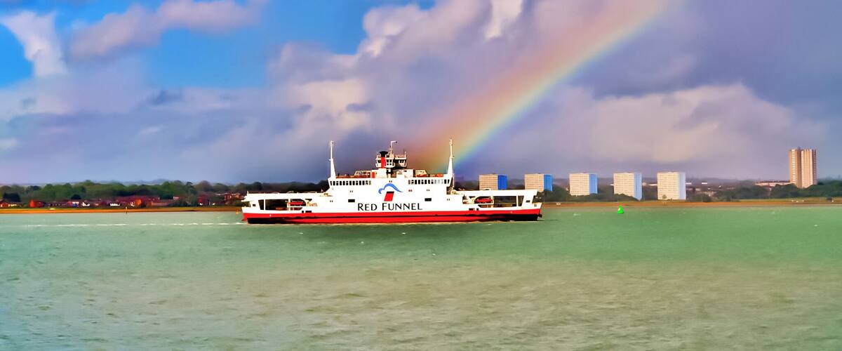 Red Funnel ferry sailing up Southampton water passing Weston Shore and through a rainbow.