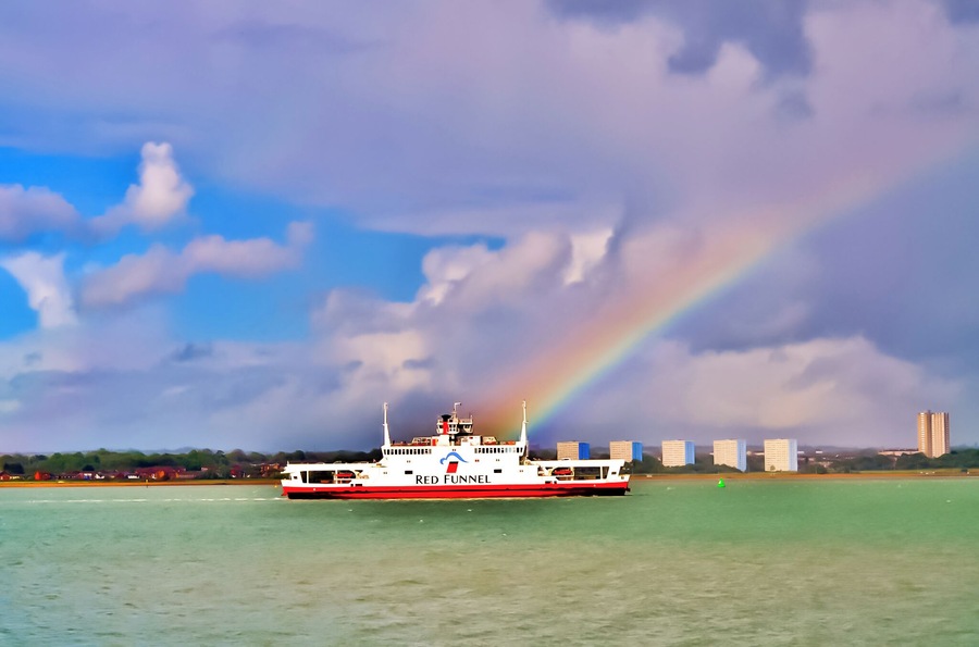 Red Funnel ferry sailing up Southampton water passing Weston Shore and through a rainbow.
