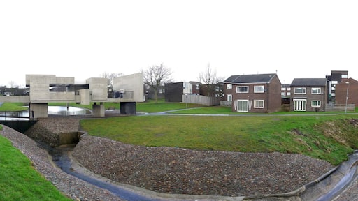 The heart of Peterlee Victor Pasmore's 'Apollo Pavilion' can be seen to the left, crossing the stream, amid a typical residential scene in Peterlee new town, which characteristically includes lots of open space around scattered houses and low level apartment blocks.