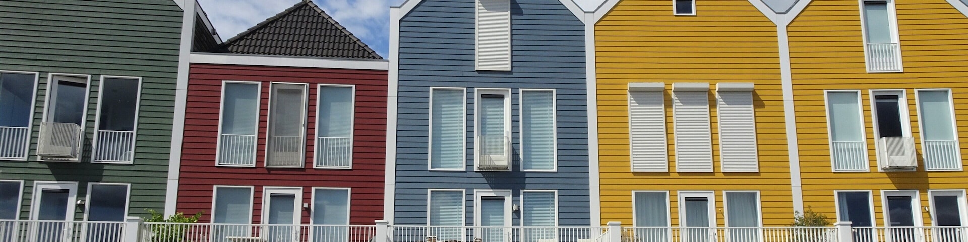 Una hilera de casas coloridas con balcones y barandillas.