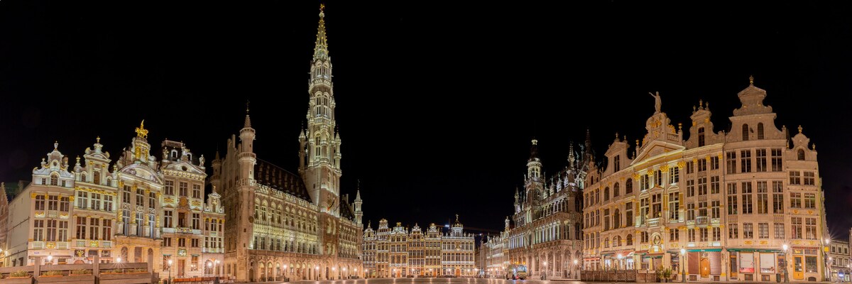 Een groot, verlicht historisch gebouwcomplex in de nacht.