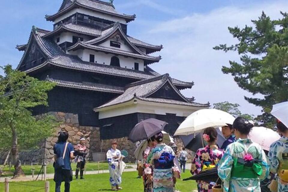 Un castell japonès tradicional amb turistes portant quimonos.