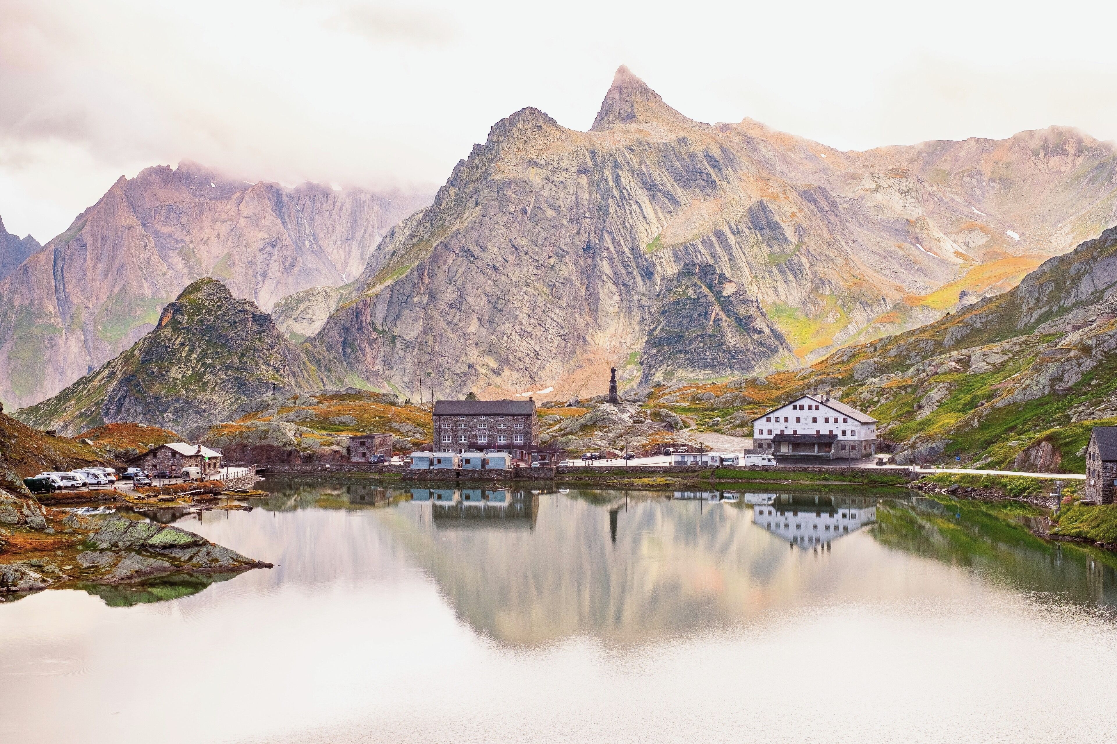 A mountainous landscape with a lake, a church, and several buildings.