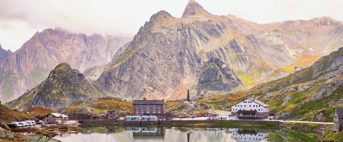 A mountainous landscape with a lake, a church, and several buildings.
