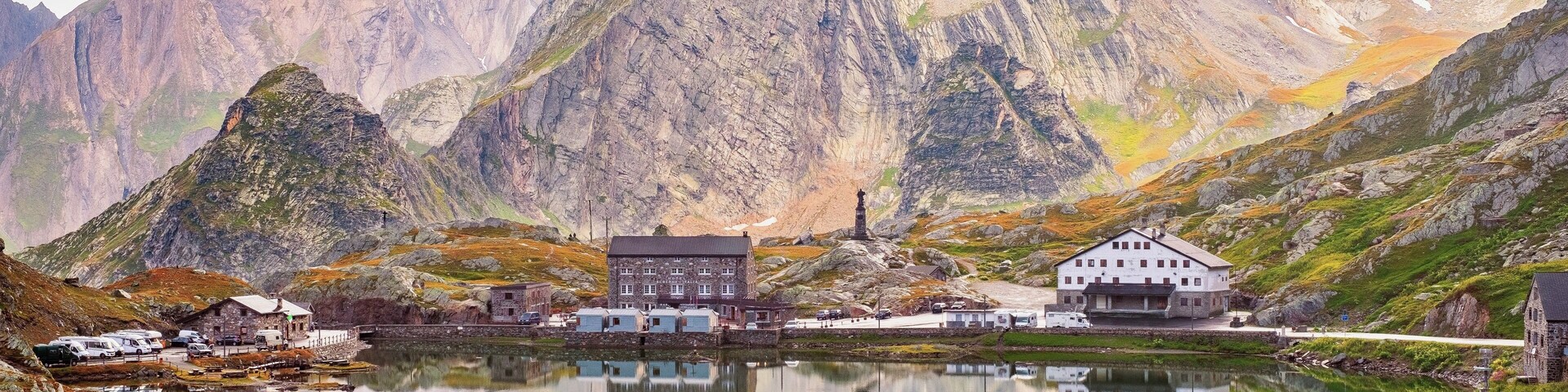 A mountainous landscape with a lake, a church, and several buildings.
