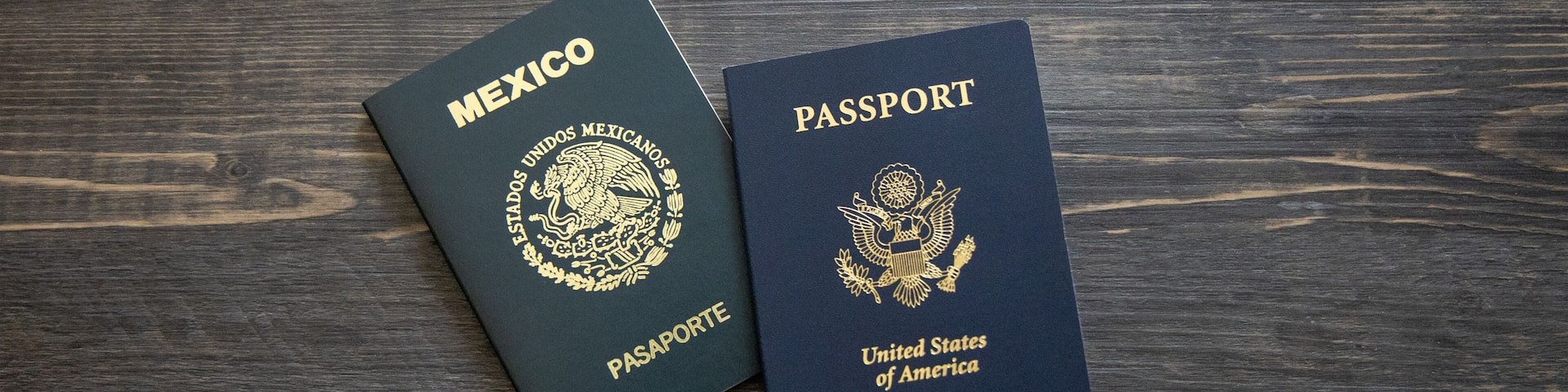 Mexican and American passports. Two passports with dark wooden background.