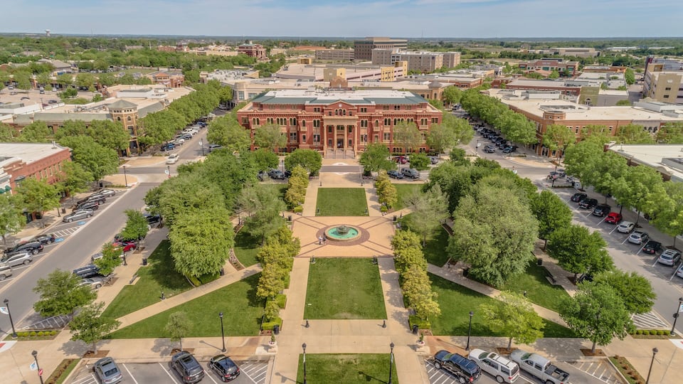 A large red building with a central courtyard and surrounding parking lots.