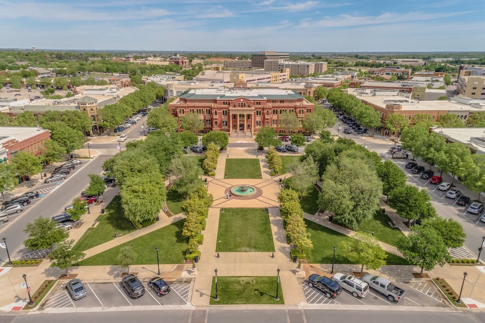A large red building with a central courtyard and surrounding parking lots.