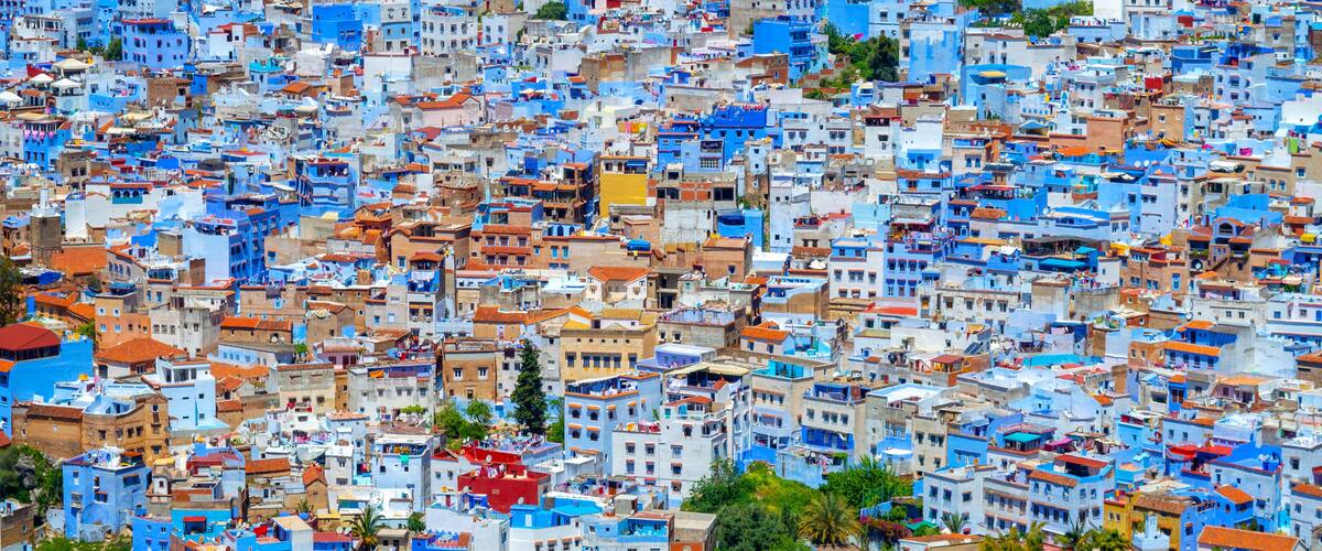 A densely packed urban area with buildings predominantly painted in shades of blue and white, with some red roofs.