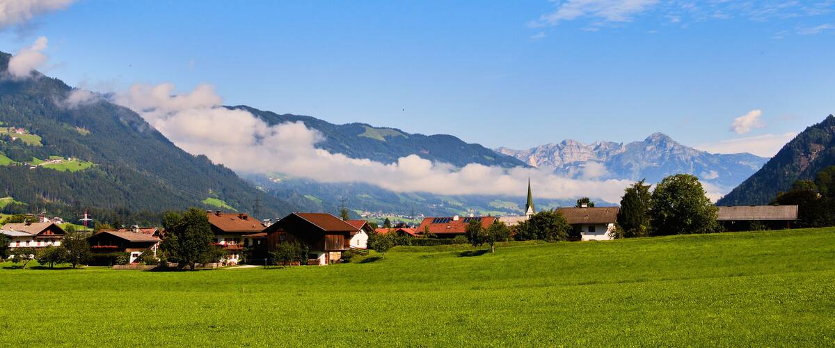 A mountainous landscape with houses and green fields.