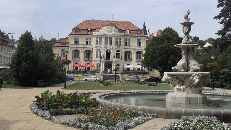 A historic building with a fountain in the foreground.