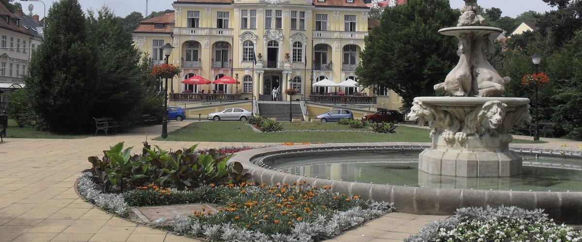 A historic building with a fountain in the foreground.