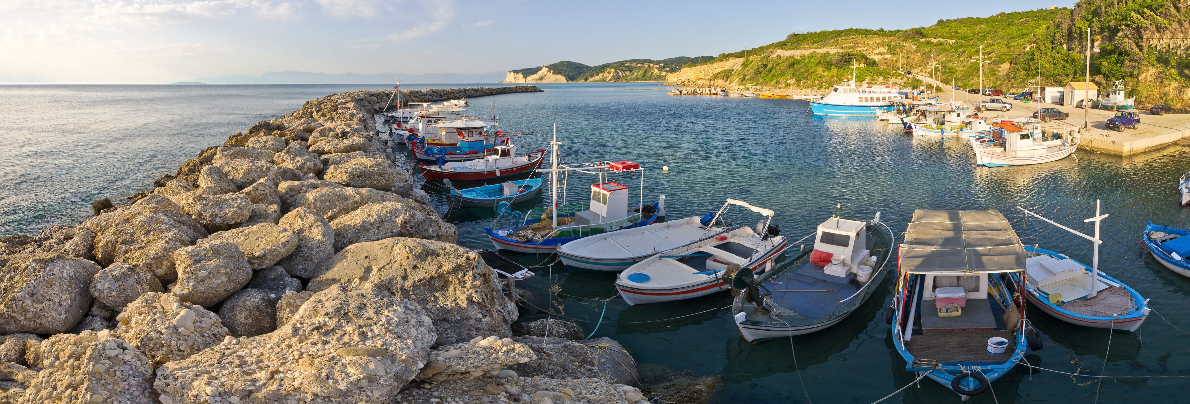A harbor with boats docked along a rocky breakwater.