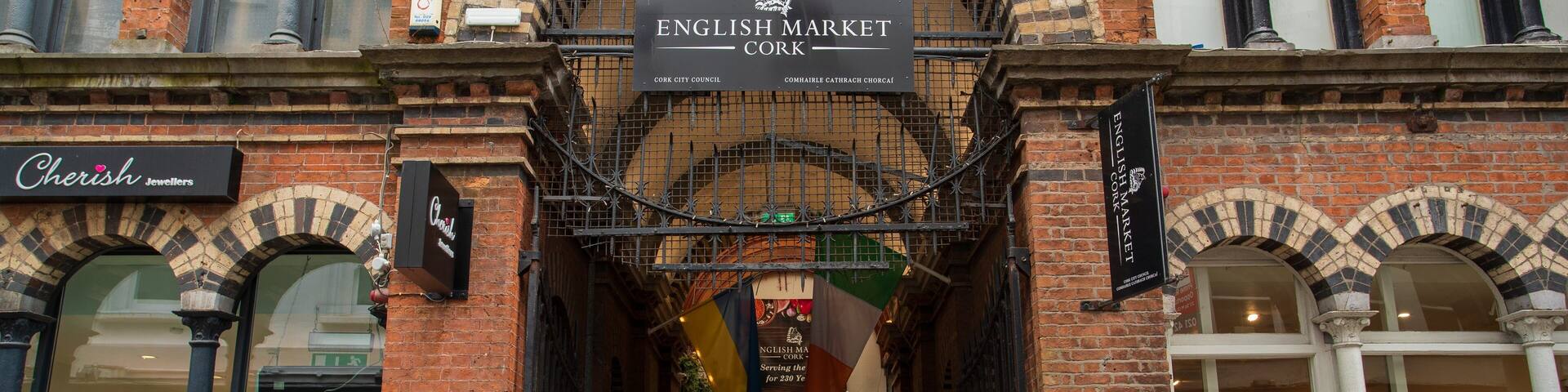 The English Market in Cork, featuring brick architecture and a crowd of people.