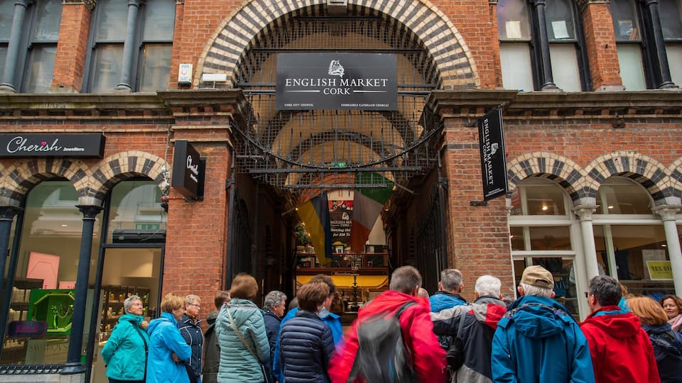 The English Market in Cork, featuring brick architecture and a crowd of people.