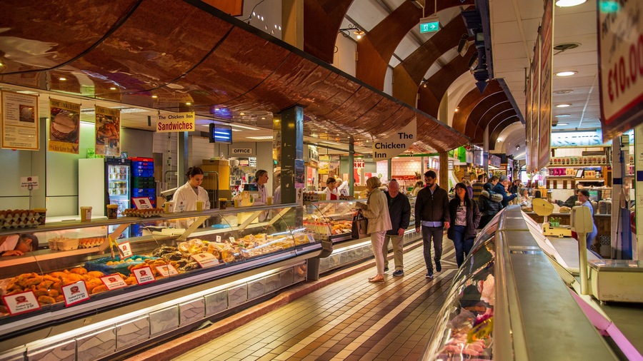 A food market with a deli counter displaying various meats and cheeses.