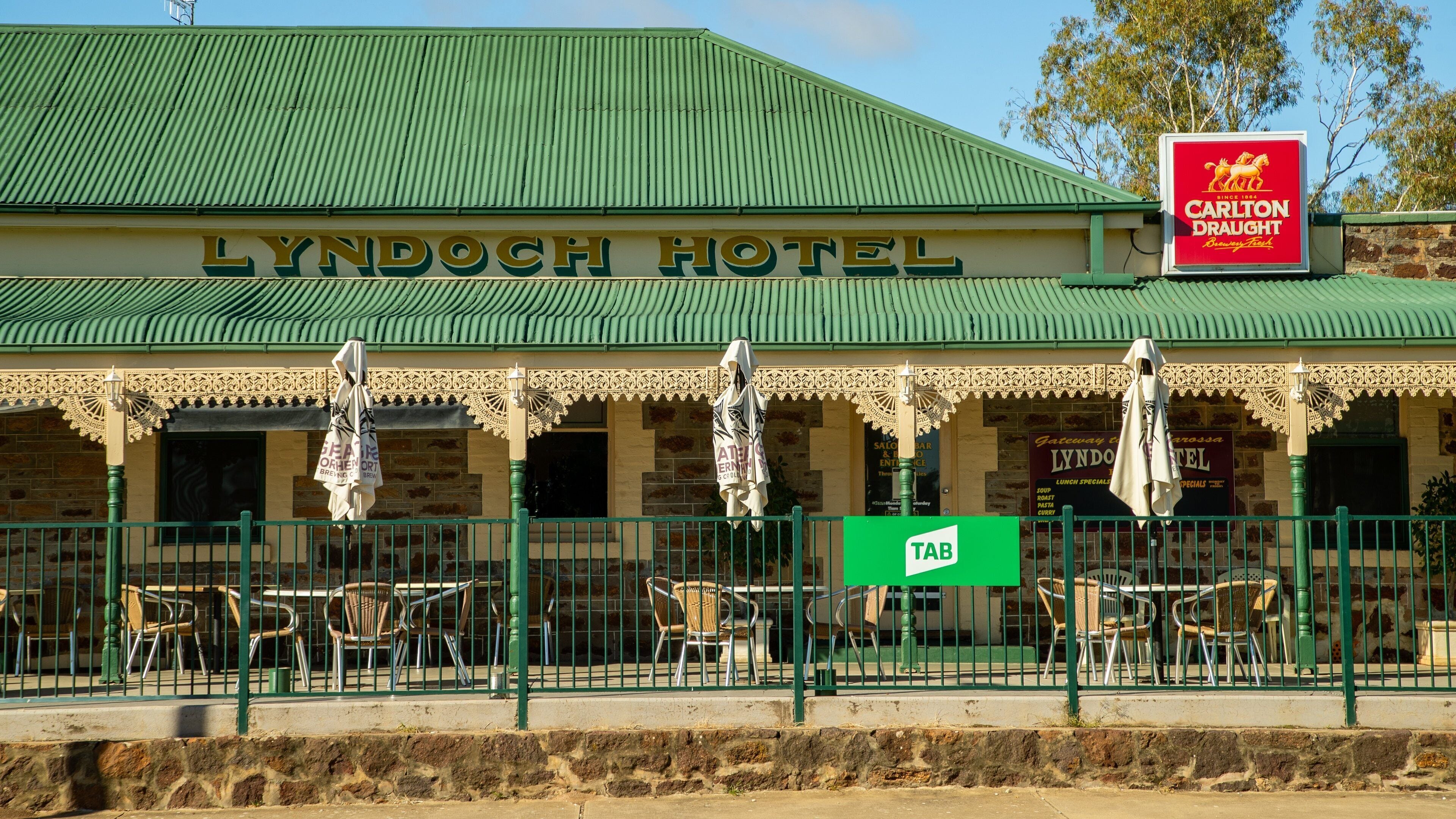The Lyndoch Hotel with a green roof and outdoor seating area.
