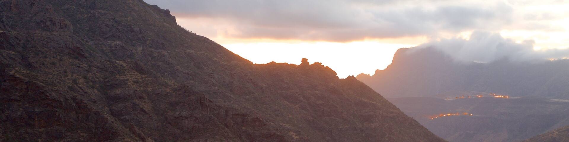 Tejeda which includes a sunset, a small town or village and mist or fog