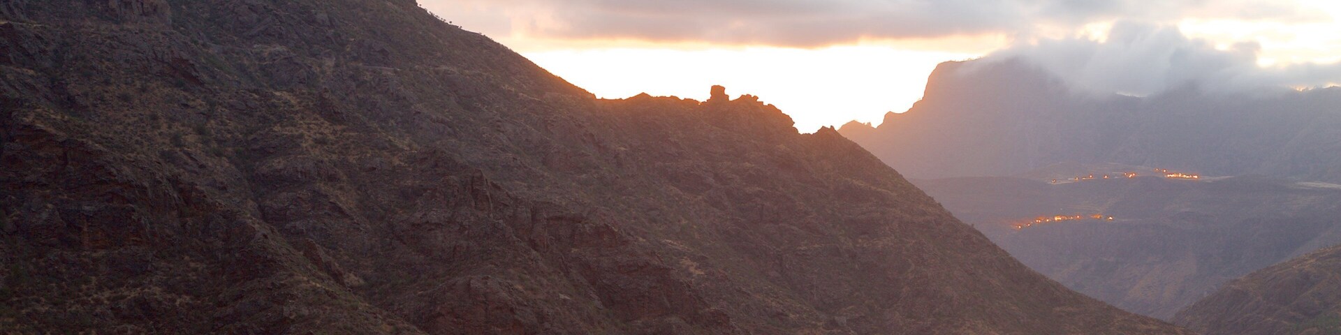 A mountainous landscape with a village at the base.