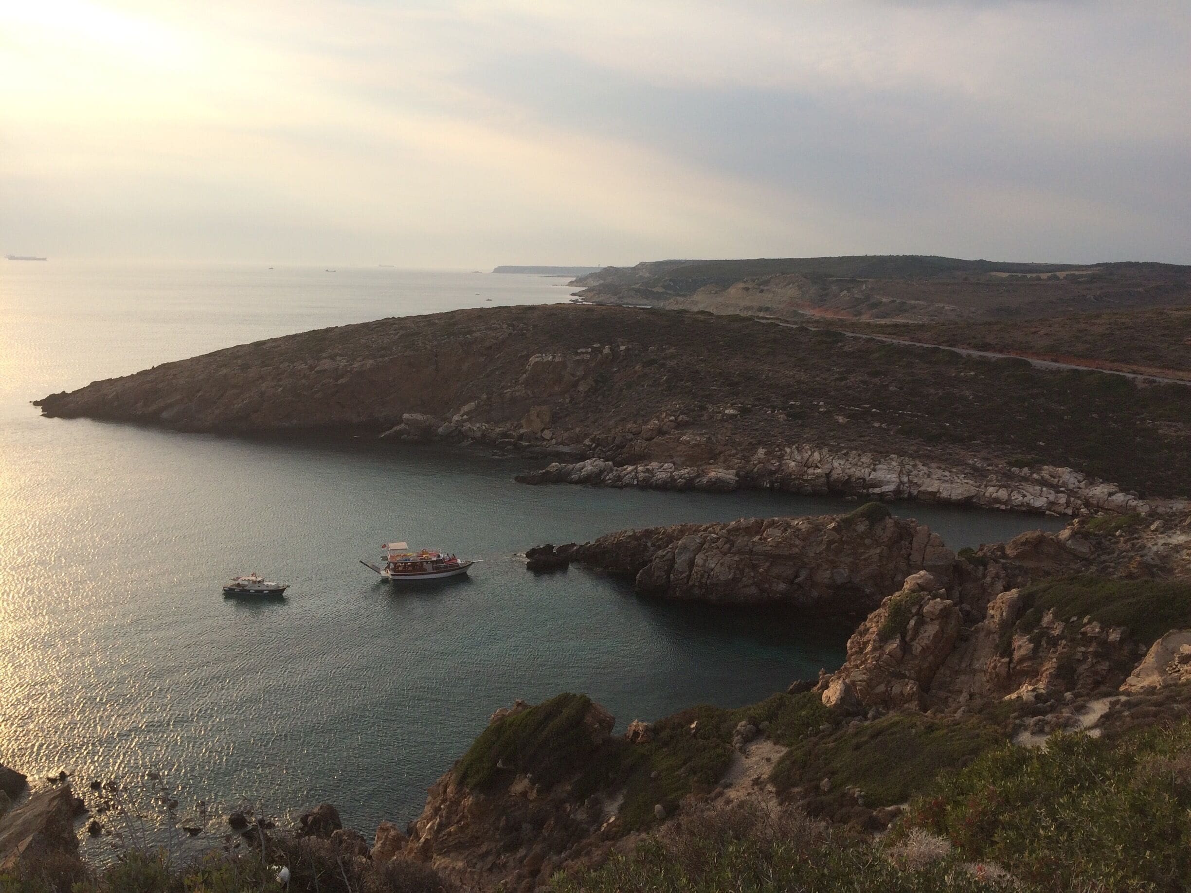 A coastal landscape with rocky cliffs and calm sea.