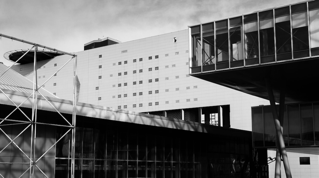 A modern building with a grid of windows and a curved glass structure.