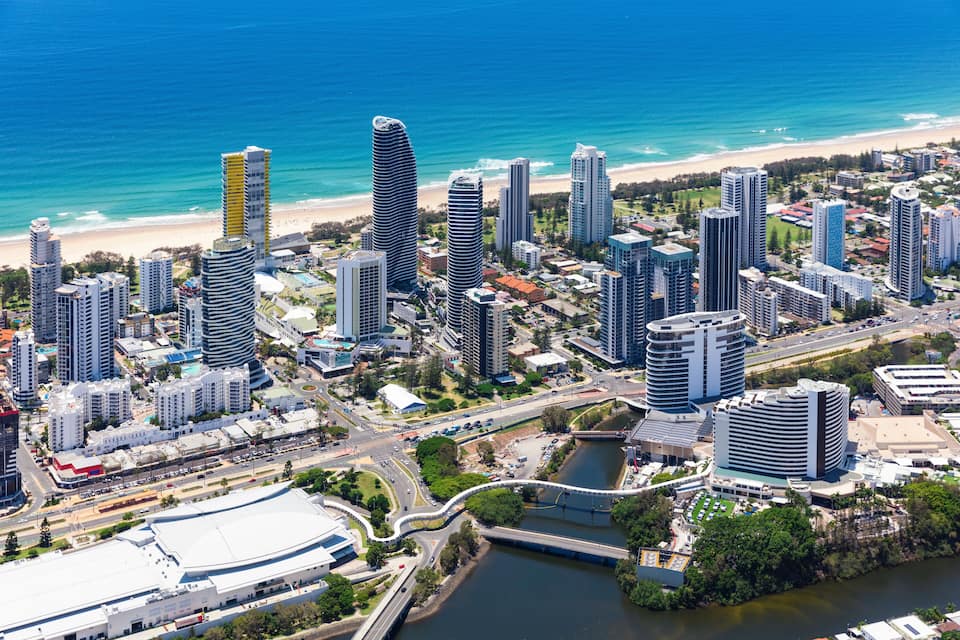 Paisatge urbà costaner amb edificis alts, una platja i un riu.